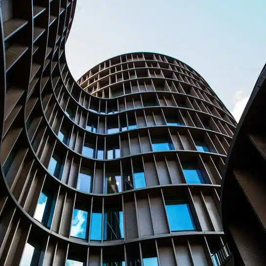 façade-ondulee Façade courbe d’un immeuble contemporain vue depuis le sol, illustrant la modernisation apportée par Azuracom à la plateforme de gestion d’adhérents de l’UNSFA